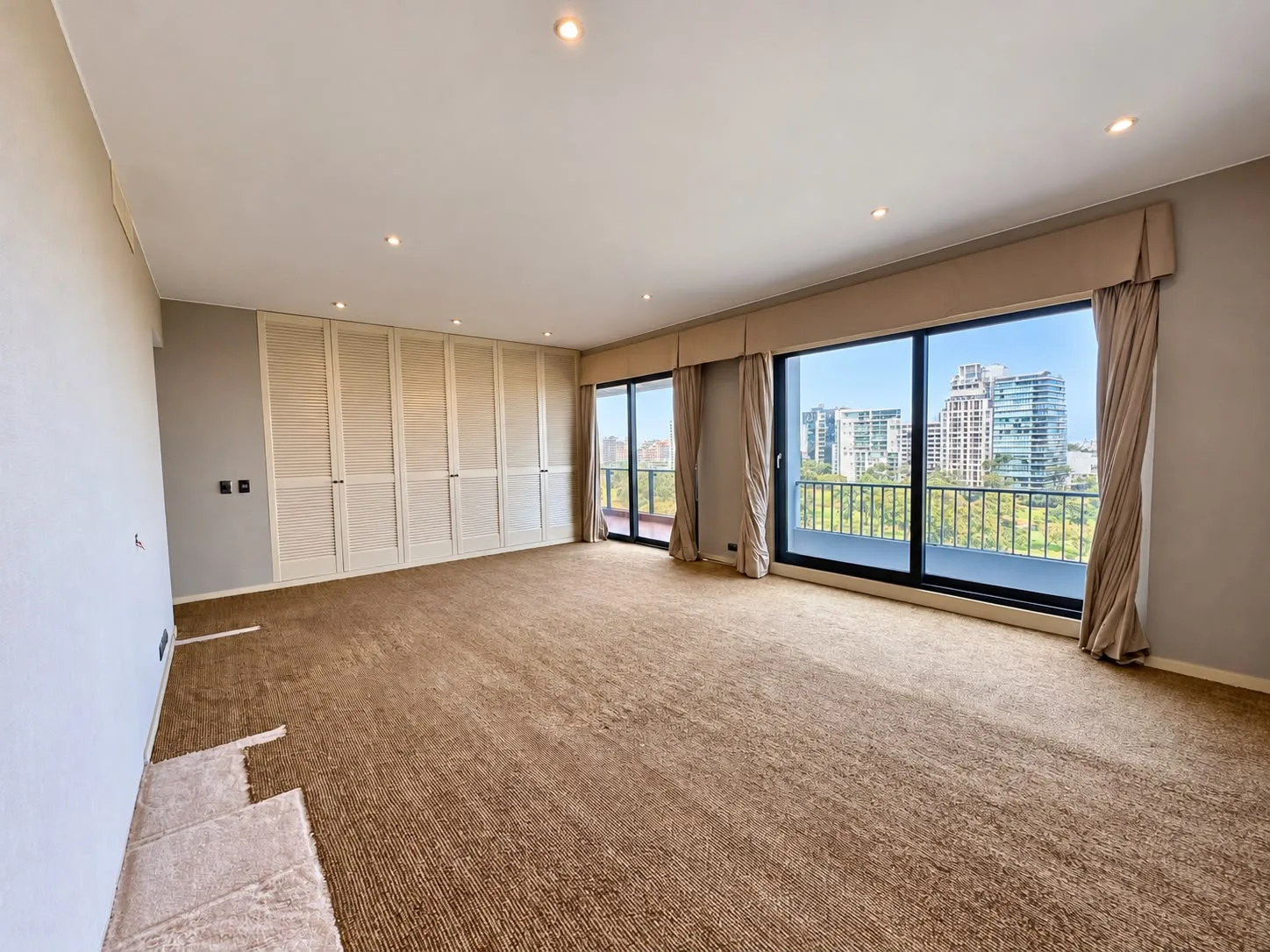 Dormitorio con ventanales hacia el campo de golf y closets empotrados