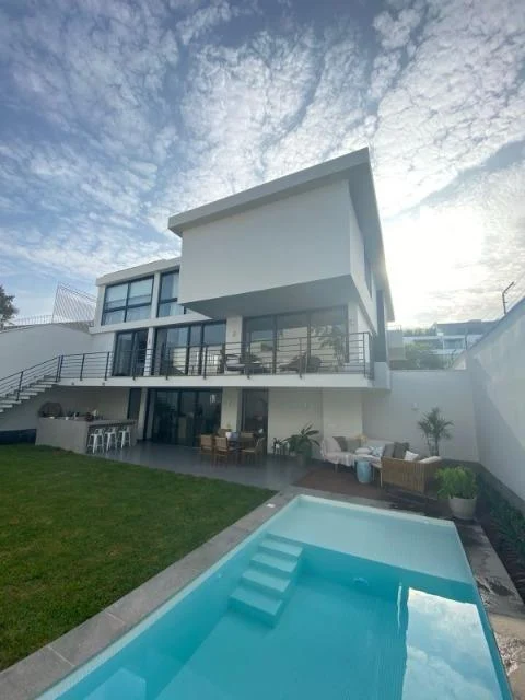 La casa vista desde la piscina y el jardín