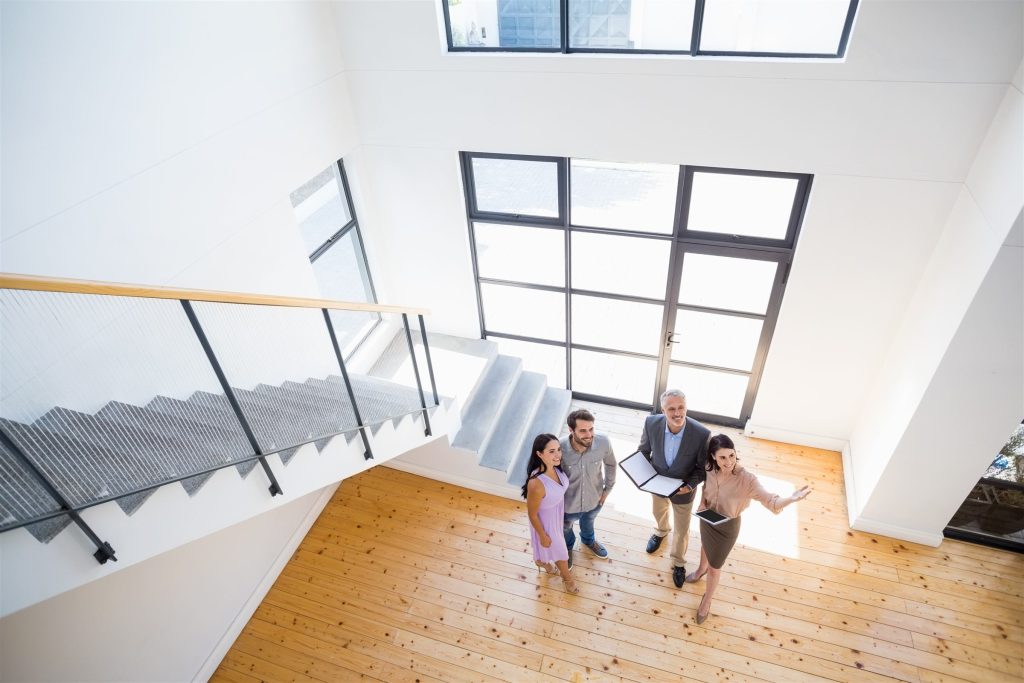 Agente inmobiliaria mostrando un departamento a una pareja