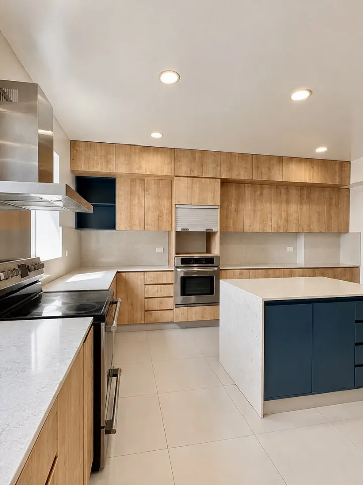 Cocina remodelada con isla central y muebles de madera